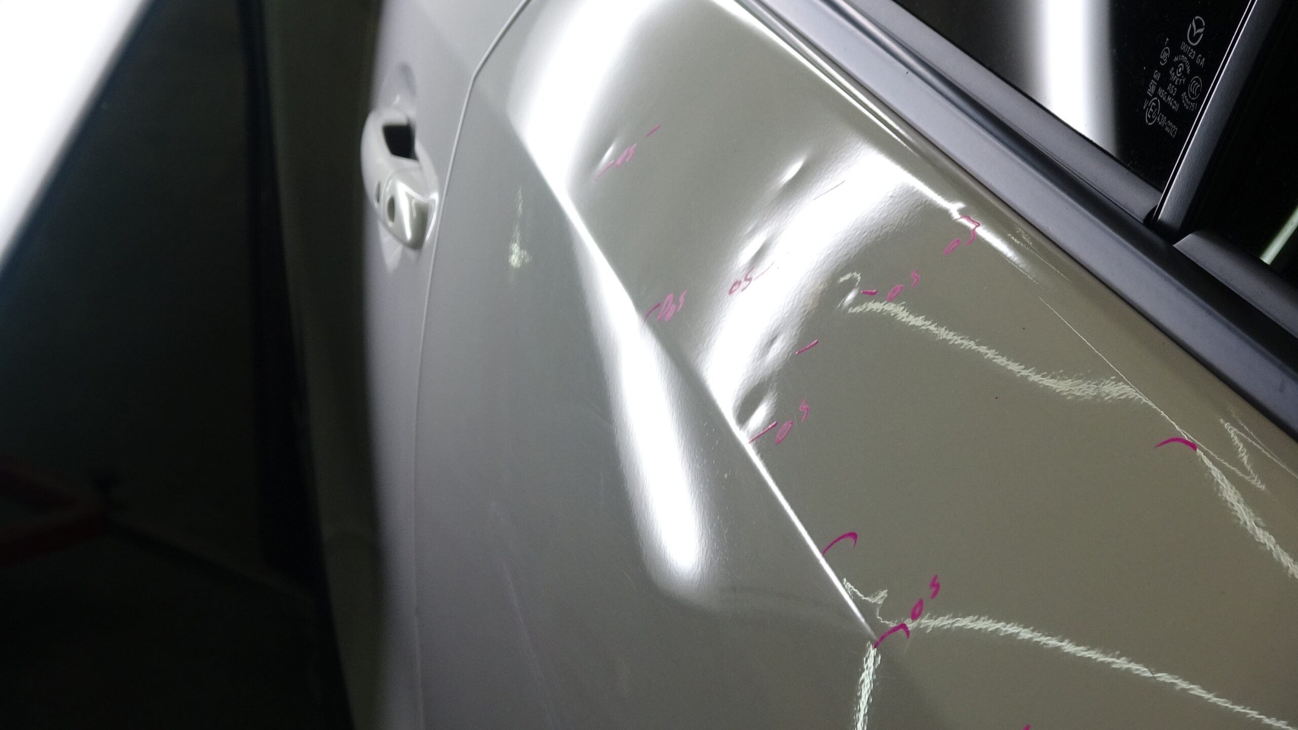 Hail dents marked for insurance inspection under PDR lighting, Denton County — hood
