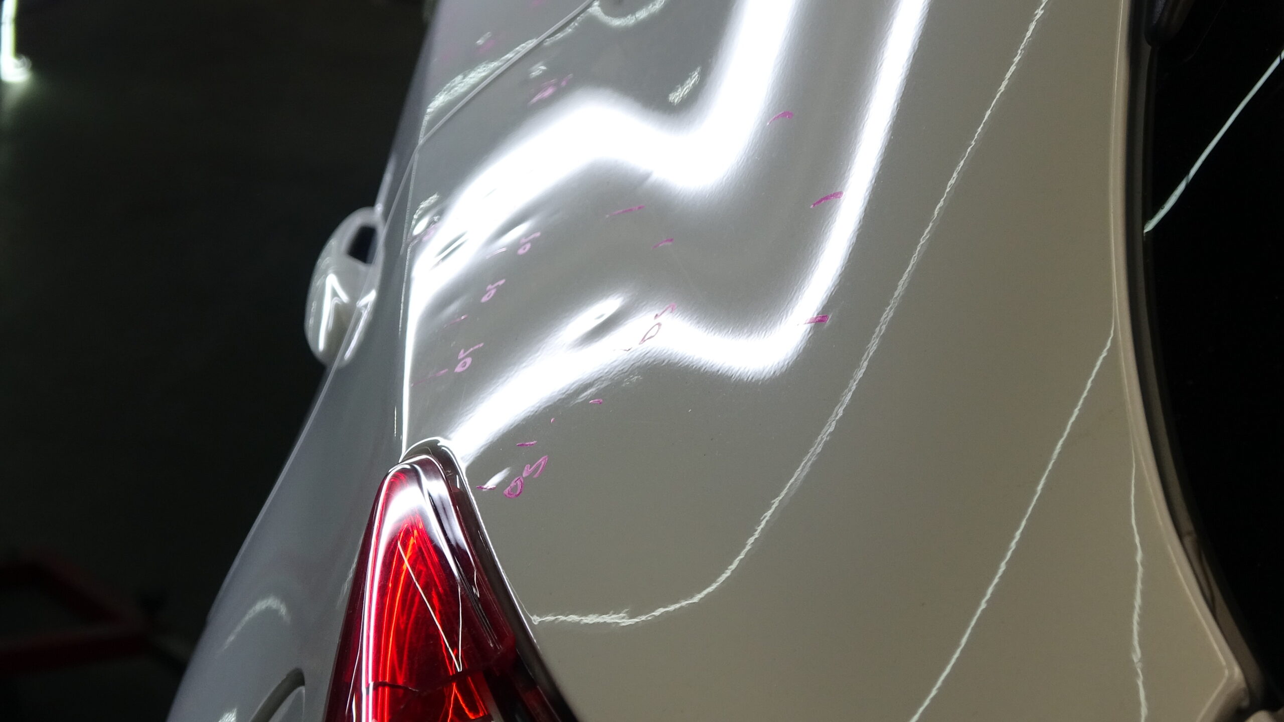 Hail dents marked for insurance inspection under PDR lighting, Denton County — door