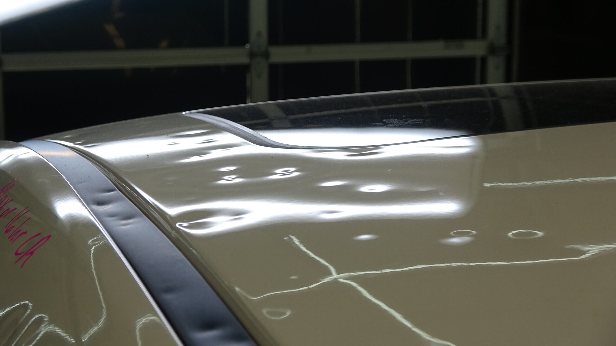 Hail dents marked for insurance inspection under PDR lighting, Denton County — roof